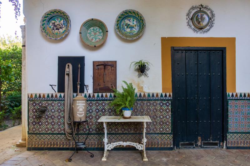 Pared de patio andaluz revestida con azulejos hasta la mitad