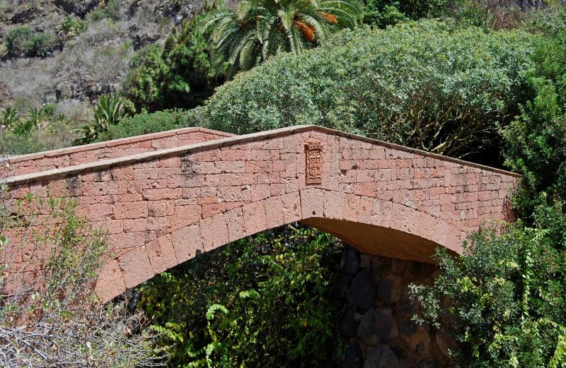 Puente de piedra volcánica en el Jardín Canario