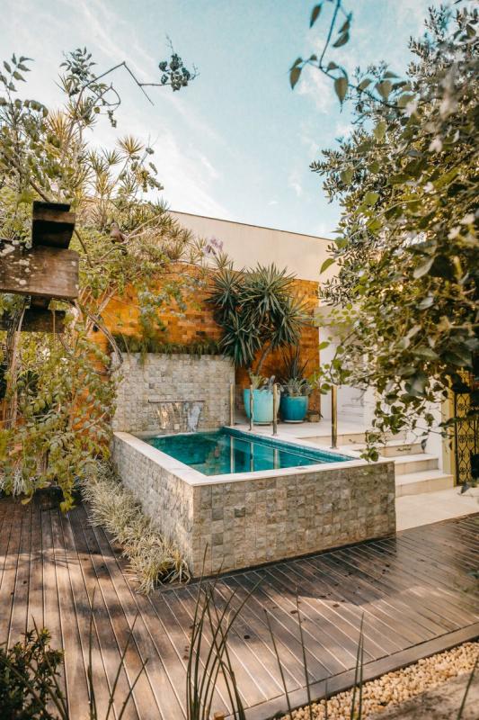 Jardín pequeño moderno con piscina elevada y deck de madera