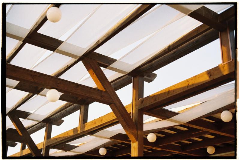Pérgola de madera con cubierta de tela y luces colgantes